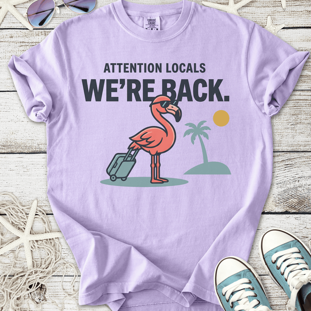 Purple t-shirt with a flamingo graphic, featuring suitcase and palm trees, perfect for summer vibes.