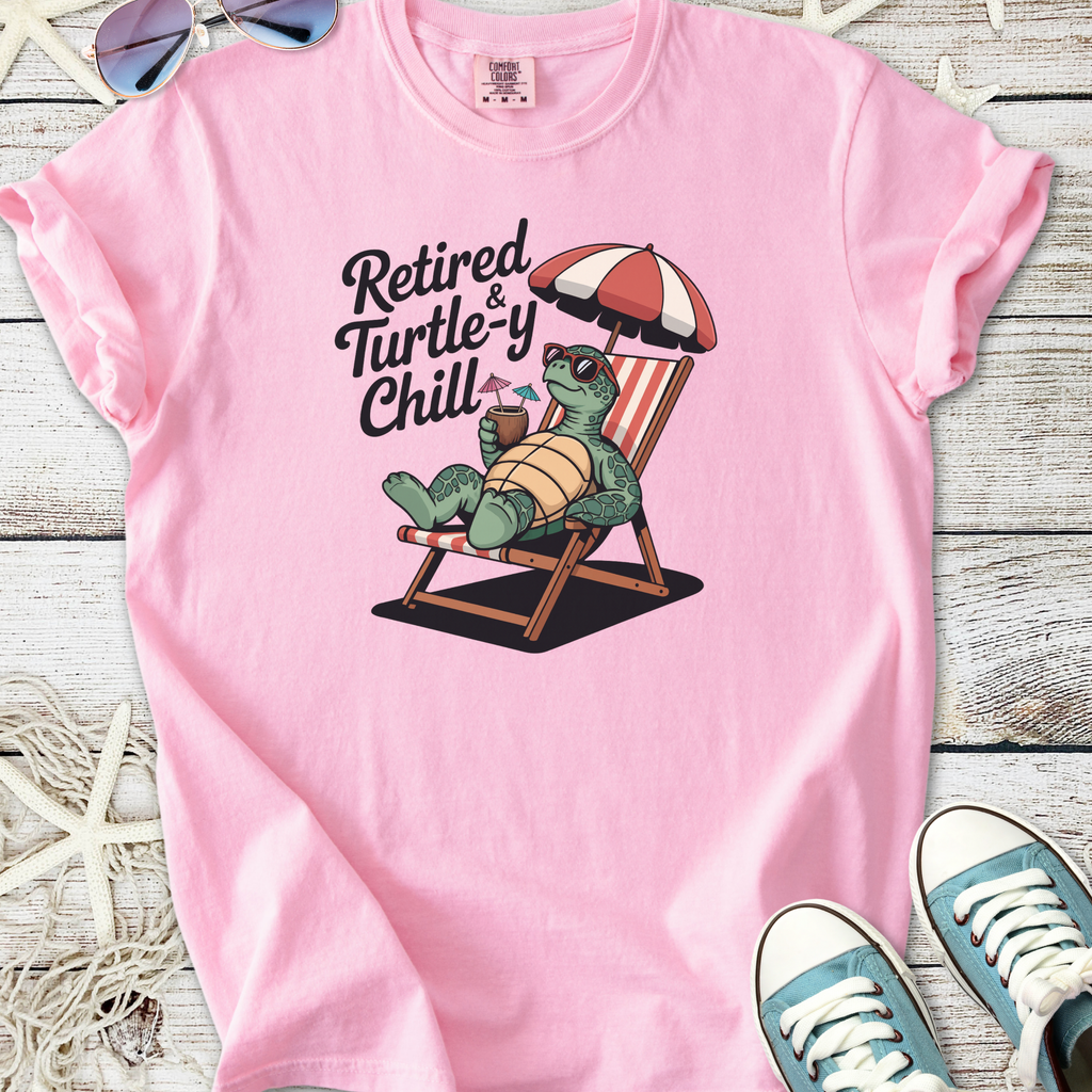 Pink t-shirt featuring a relaxed turtle graphic with the phrase 'Retired & Turtle-y Chill'