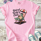 Pink t-shirt featuring a relaxed turtle graphic with the phrase 'Retired & Turtle-y Chill'