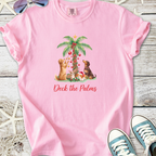 Pink t-shirt featuring playful dogs decorating a palm tree with Christmas ornaments. Cute and festive design.