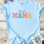 Light blue t-shirt with 'Beach MAMA' graphic, perfect for summer outings and casual wear.