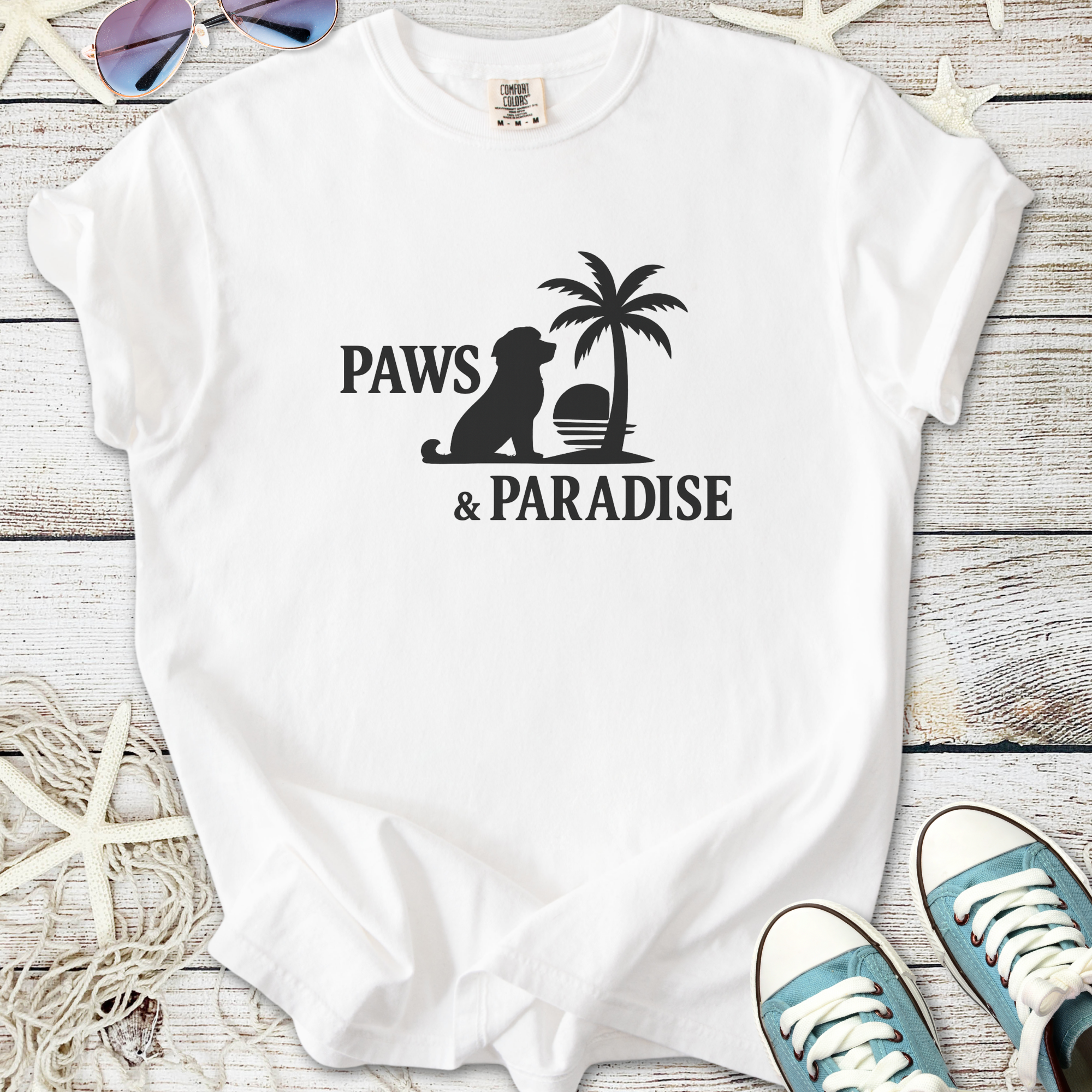 White cotton t-shirt featuring 'Paws & Paradise' design with a dog silhouette and palm tree.