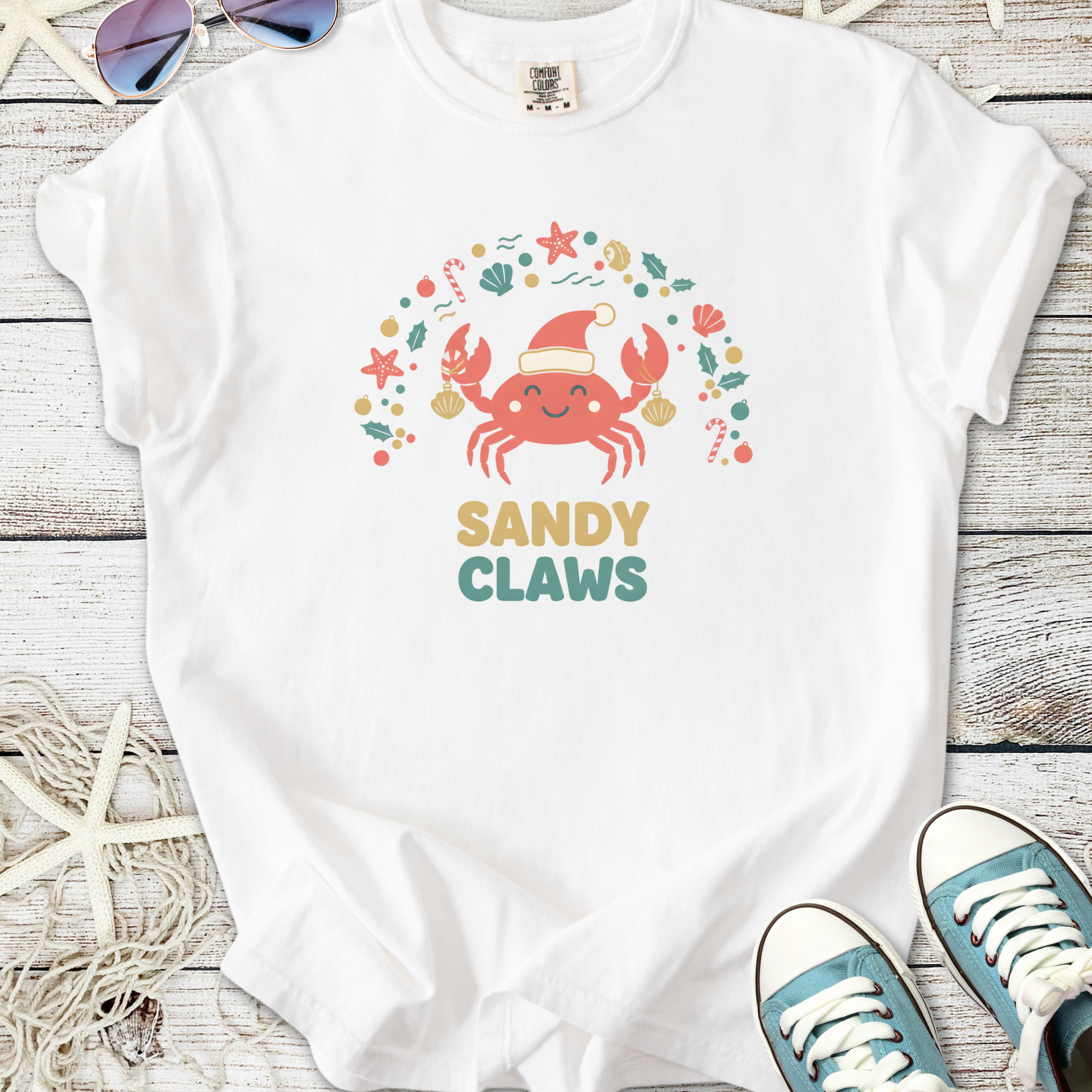 White t-shirt with 'Sandy Claws' crab graphic, perfect for beach lovers and festive occasions.