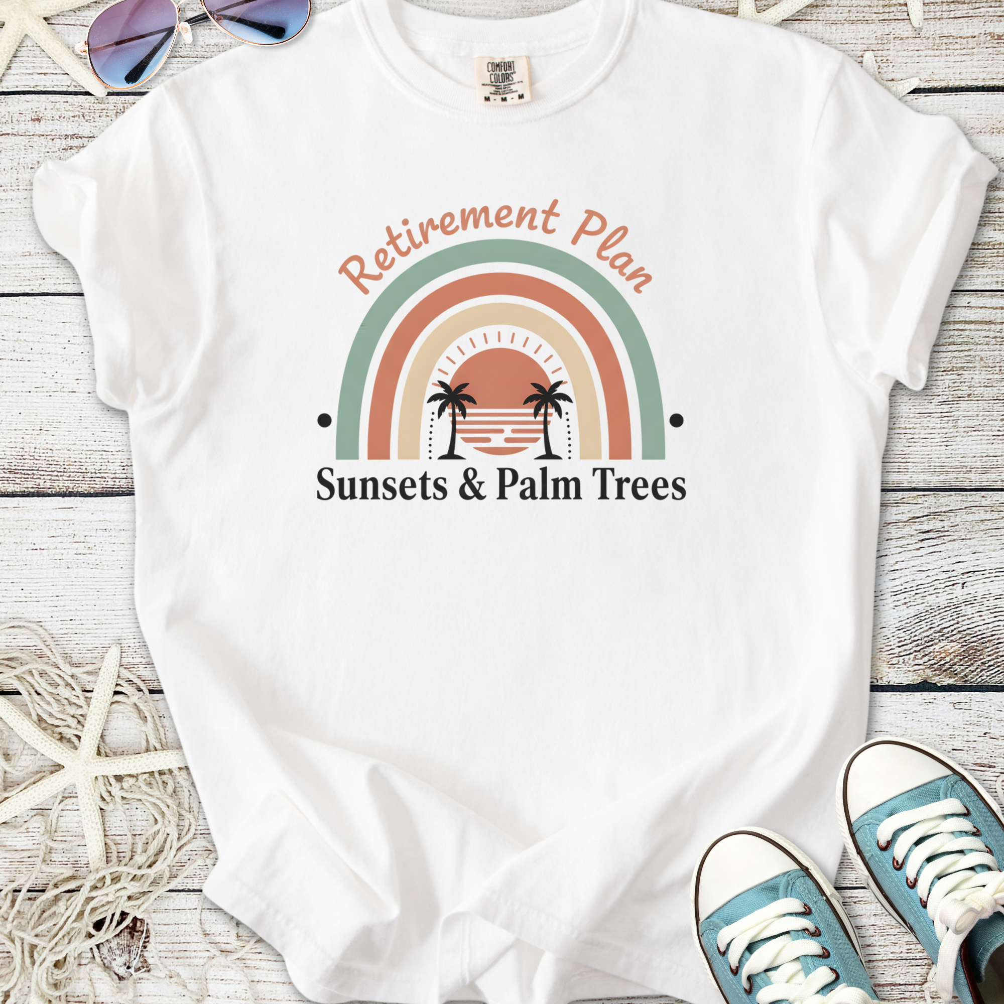 White t-shirt with 'Retirement Plan: Sunsets & Palm Trees' graphic, perfect for relaxed summer vibes.