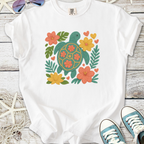 White t-shirt featuring a colorful turtle and floral design, perfect for casual summer wear.