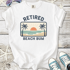 White t-shirt with 'Retired Beach Bum' graphic, featuring palm trees and sunset design, perfect for casual summer wear.