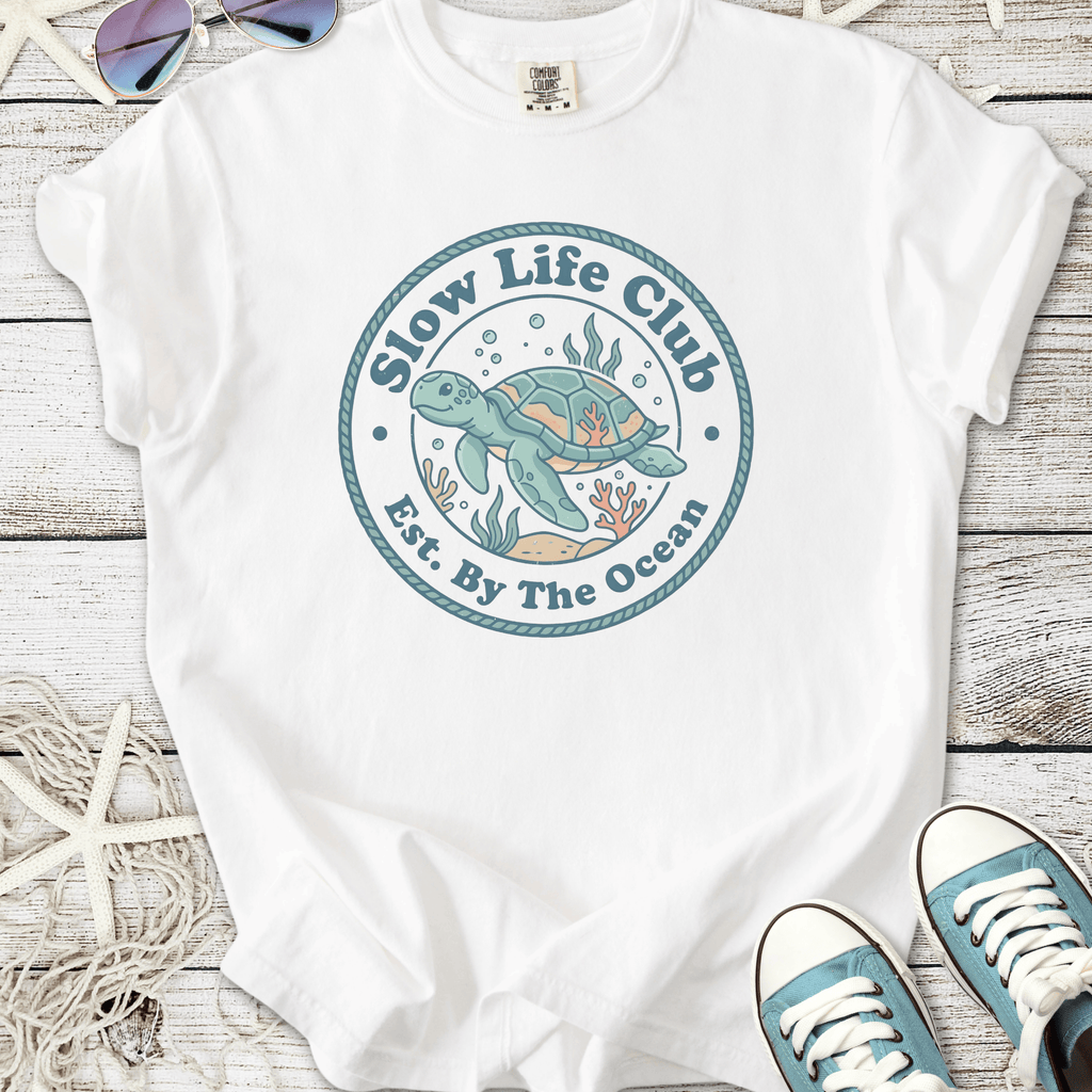 White graphic tee featuring 'Slow Life Club' with sea turtle design, perfect for ocean lovers.