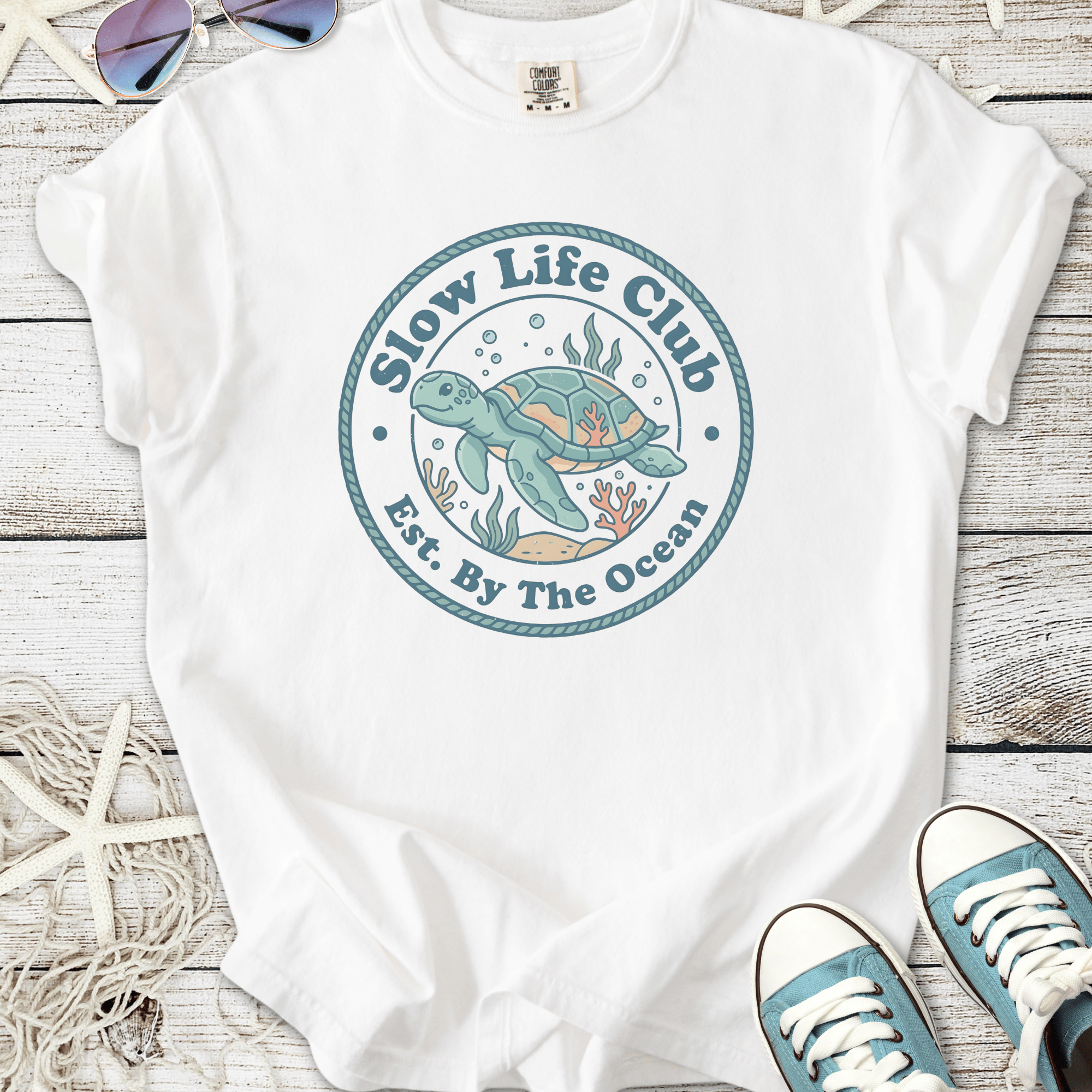 White graphic tee featuring 'Slow Life Club' with sea turtle design, perfect for ocean lovers.