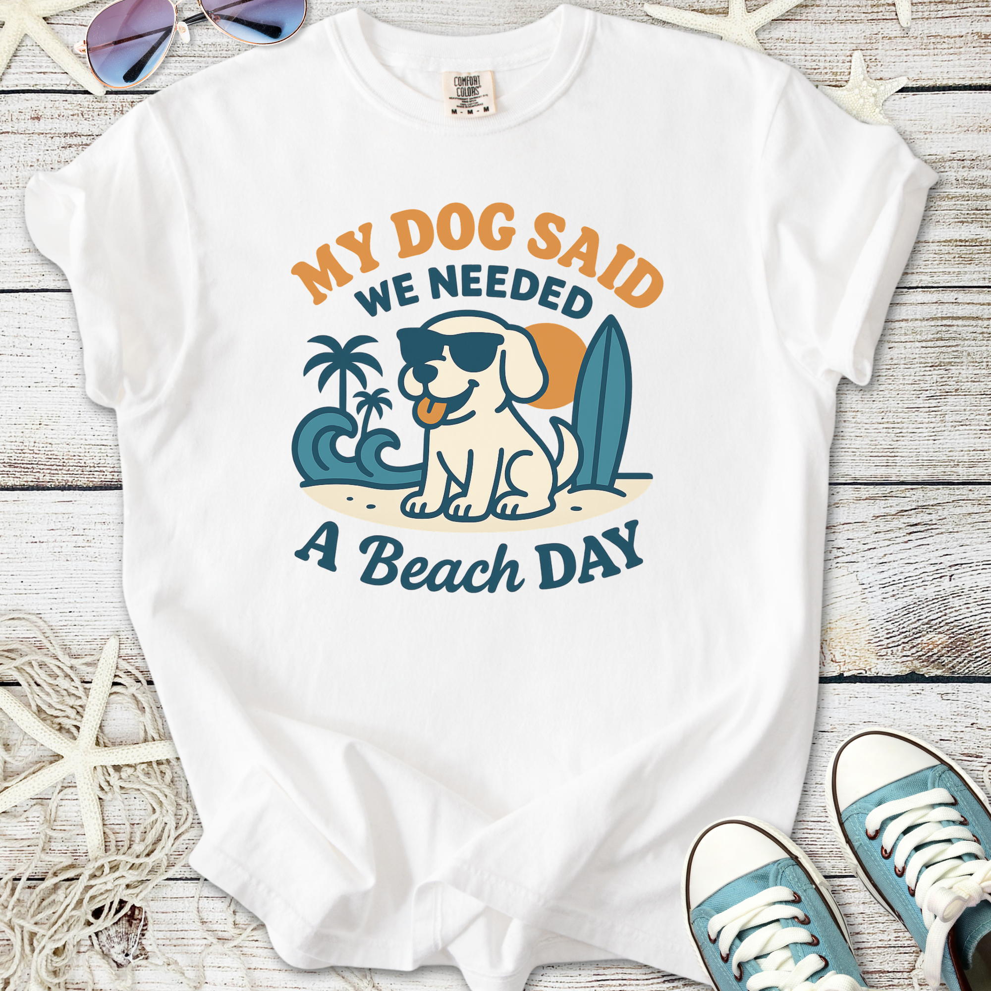 White t-shirt featuring a playful dog graphic and 'My Dog Said We Needed A Beach Day' text.