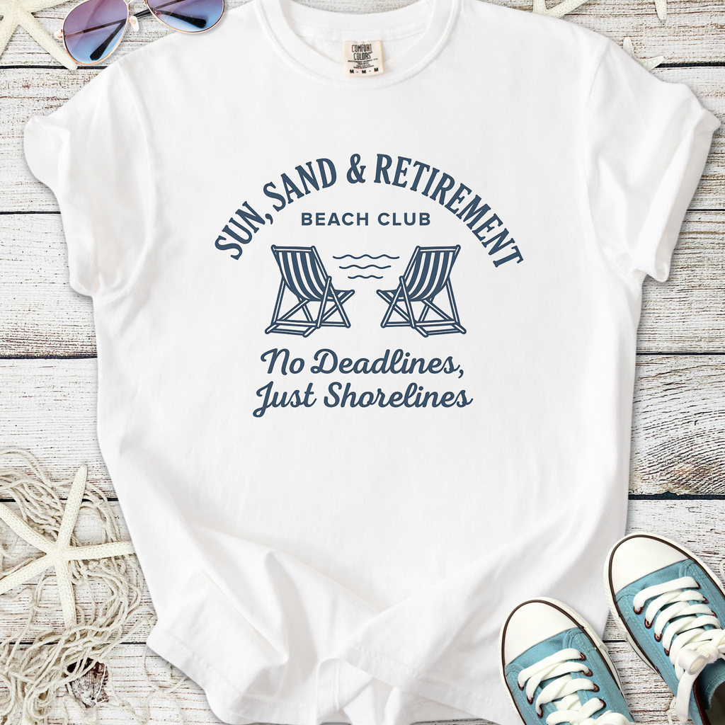 White cotton t-shirt featuring 'Sun, Sand & Retirement' beach club print with chairs and waves design.