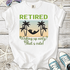 White t-shirt featuring 'Retired' graphic with palm trees and hammock design, perfect for relaxation.