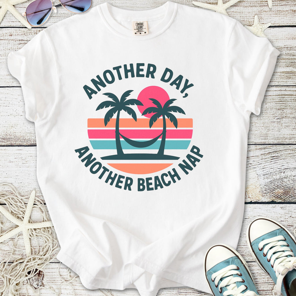 White graphic t-shirt with 'Another Day, Another Beach Nap' and palm tree design, perfect for summer.