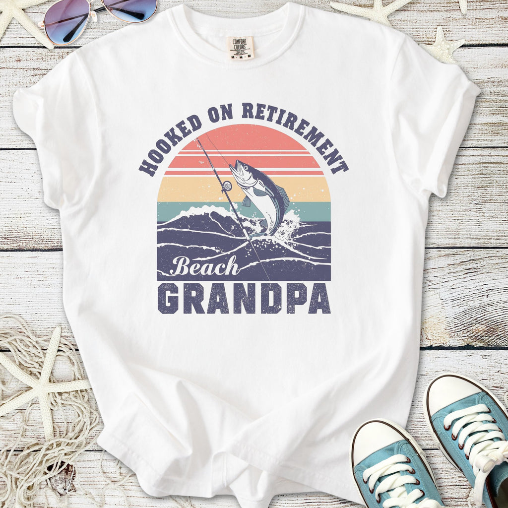 White t-shirt with 'Hooked on Retirement Beach Grandpa' graphic, featuring a fish and fishing rod design.