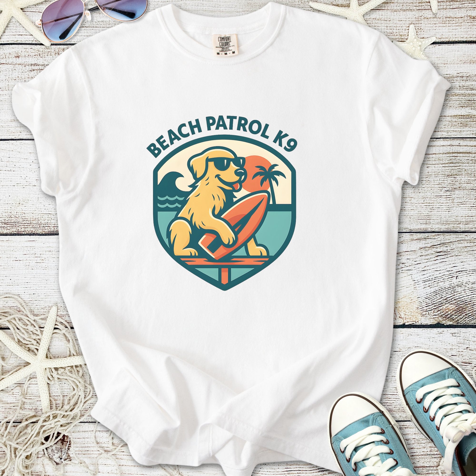 White 'Beach Patrol K9' t-shirt featuring a dog on a surfboard, perfect for beach lovers.
