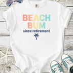 White t-shirt with 'BEACH BUM since retirement' text and palm tree design, ideal for beach lovers.