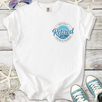 White t-shirt with 'Officially Retired' graphic, perfect for beach lovers and casual wear.