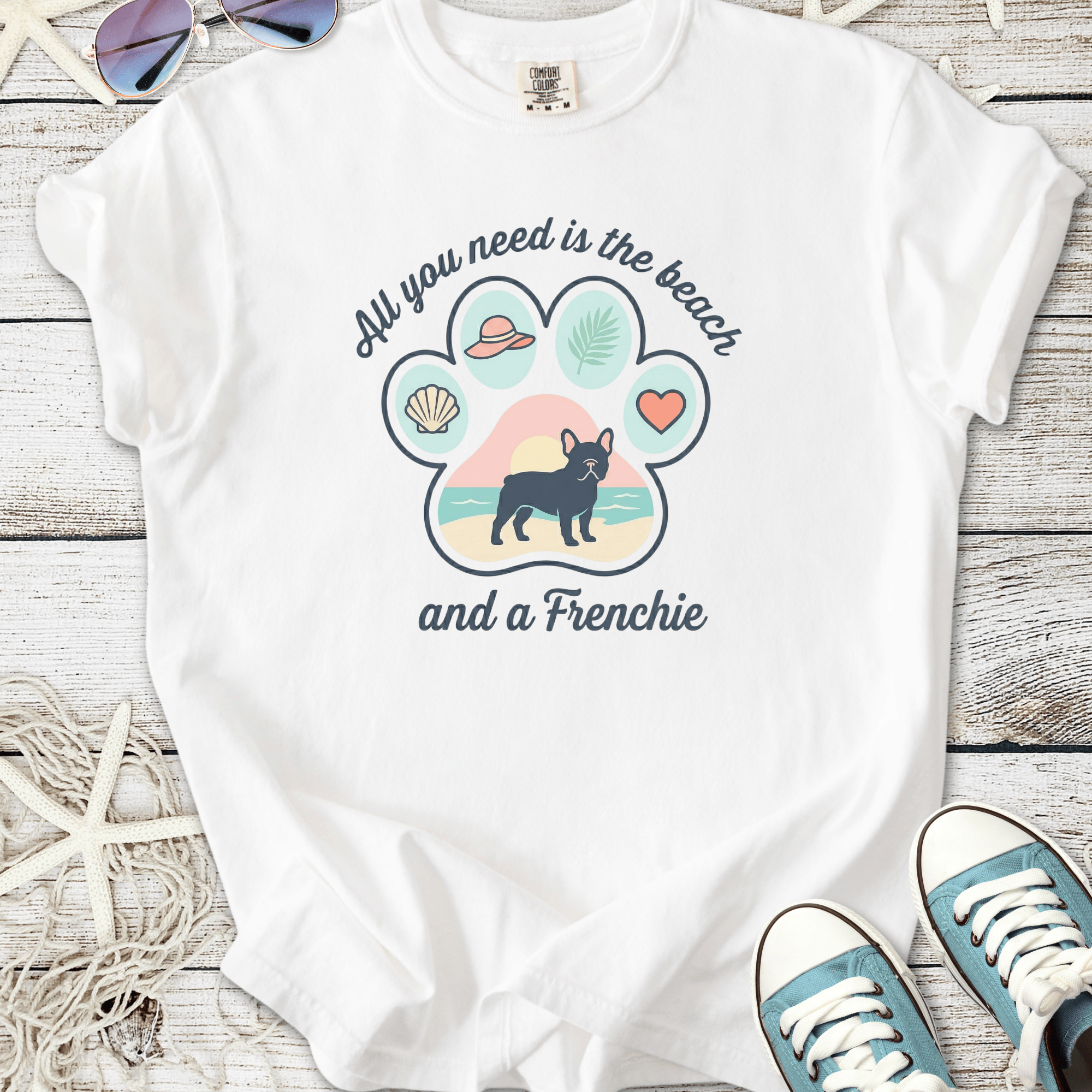 White t-shirt featuring a beach-themed Frenchie graphic and text, perfect for dog lovers.