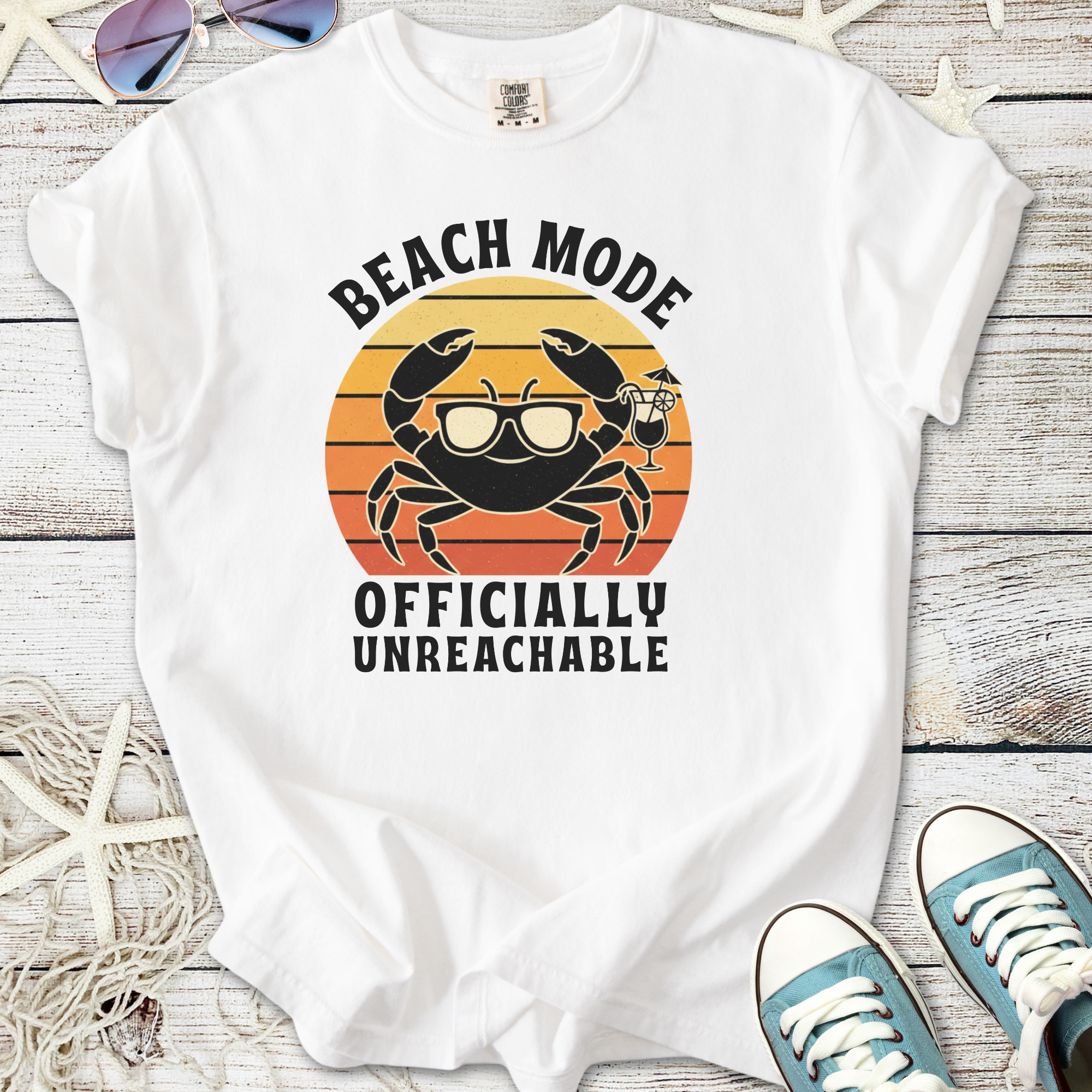 White t-shirt with 'Beach Mode Officially Unreachable' crab graphic, perfect for summer vibes.