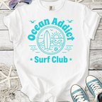 White t-shirt with 'Ocean Addict Surf Club' graphic, featuring a surfboard and ocean design.