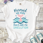 White t-shirt with 'Mermaid Off Duty' graphic, featuring a pink mermaid tail and blue waves.