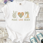 White t-shirt featuring 'Peace Love Beach' graphic with bohemian design elements and tropical colors.