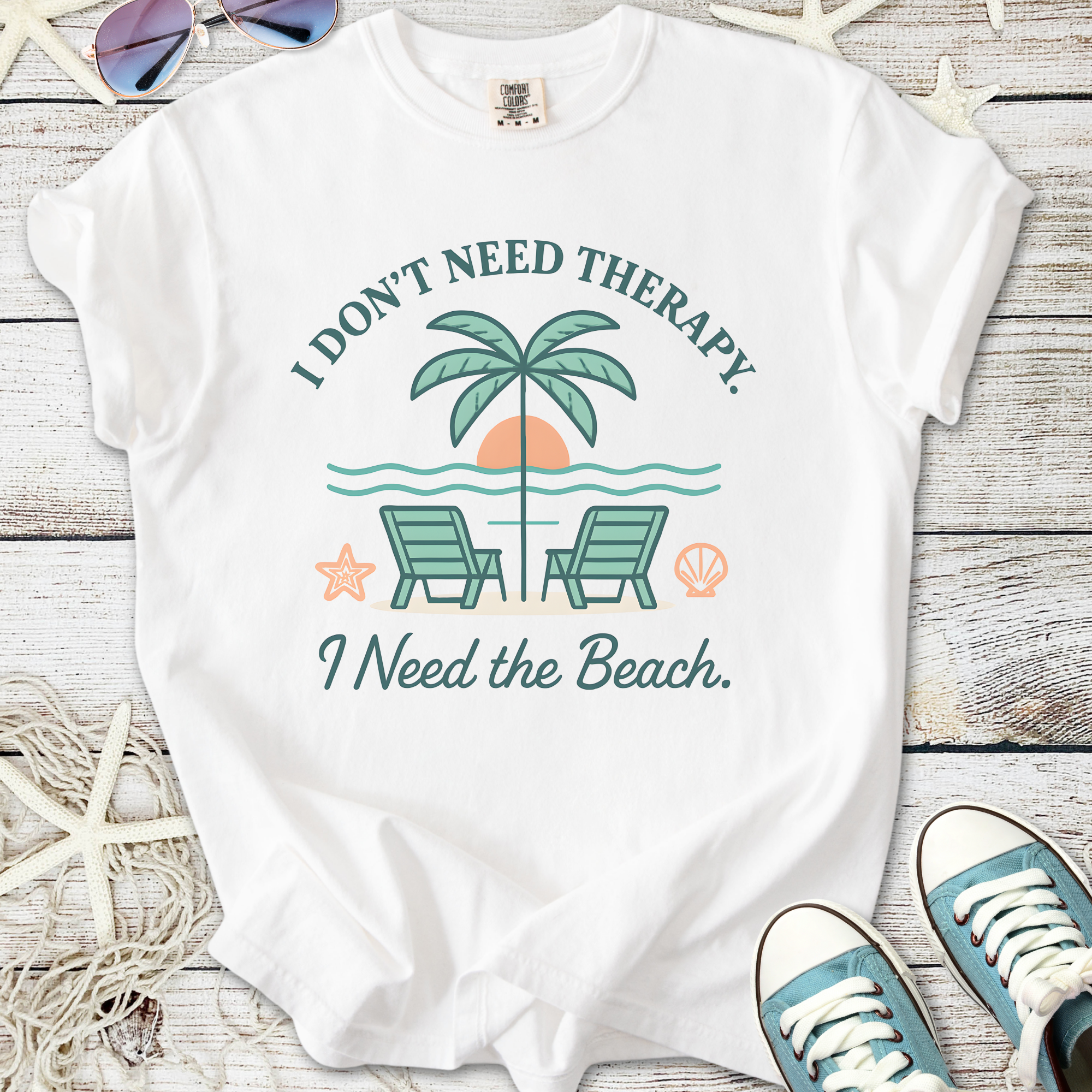 White graphic t-shirt featuring beach-themed design with palm trees and chairs, perfect for summer vibes.