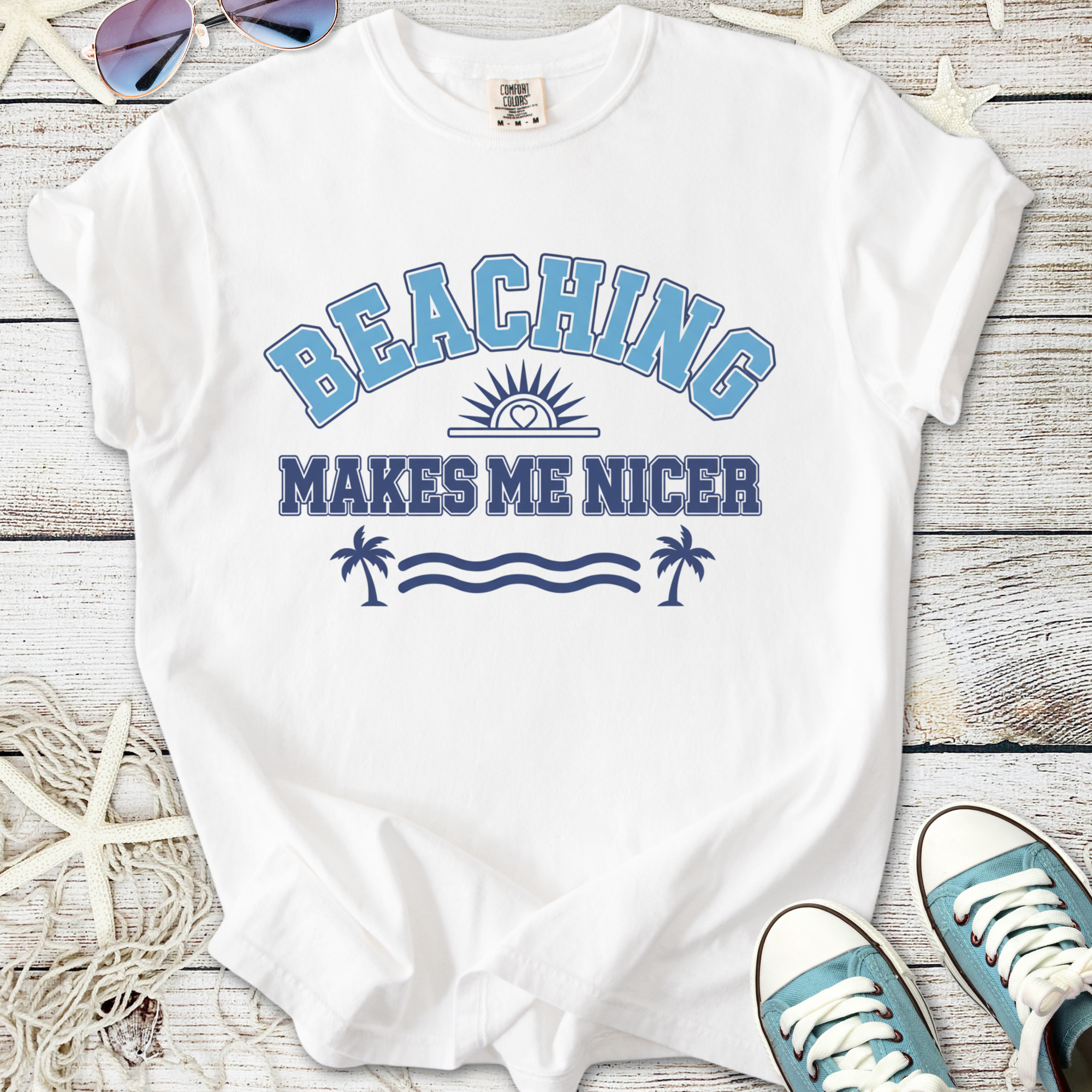 White t-shirt with 'Beaching Makes Me Nicer' graphic in blue and navy, perfect for summer outings.