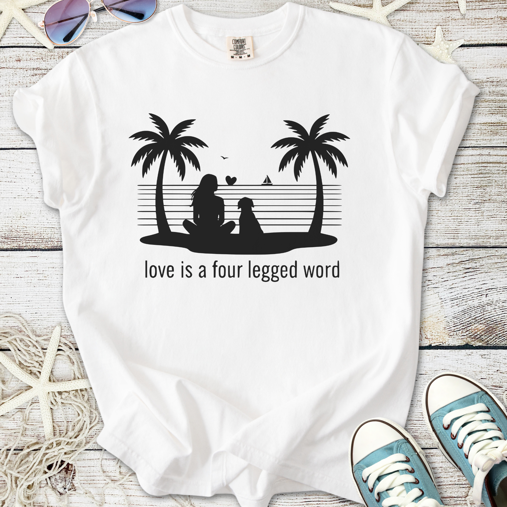 White t-shirt featuring a woman and dog silhouette with 'love is a four legged word' text, perfect for pet lovers.