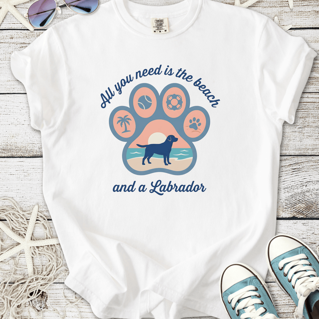 White t-shirt featuring a colorful Labrador paw print design with beach theme and motivational text.