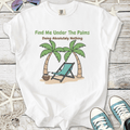 White unisex t-shirt with 'Find Me Under The Palms' graphic, featuring palm trees and a beach chair.