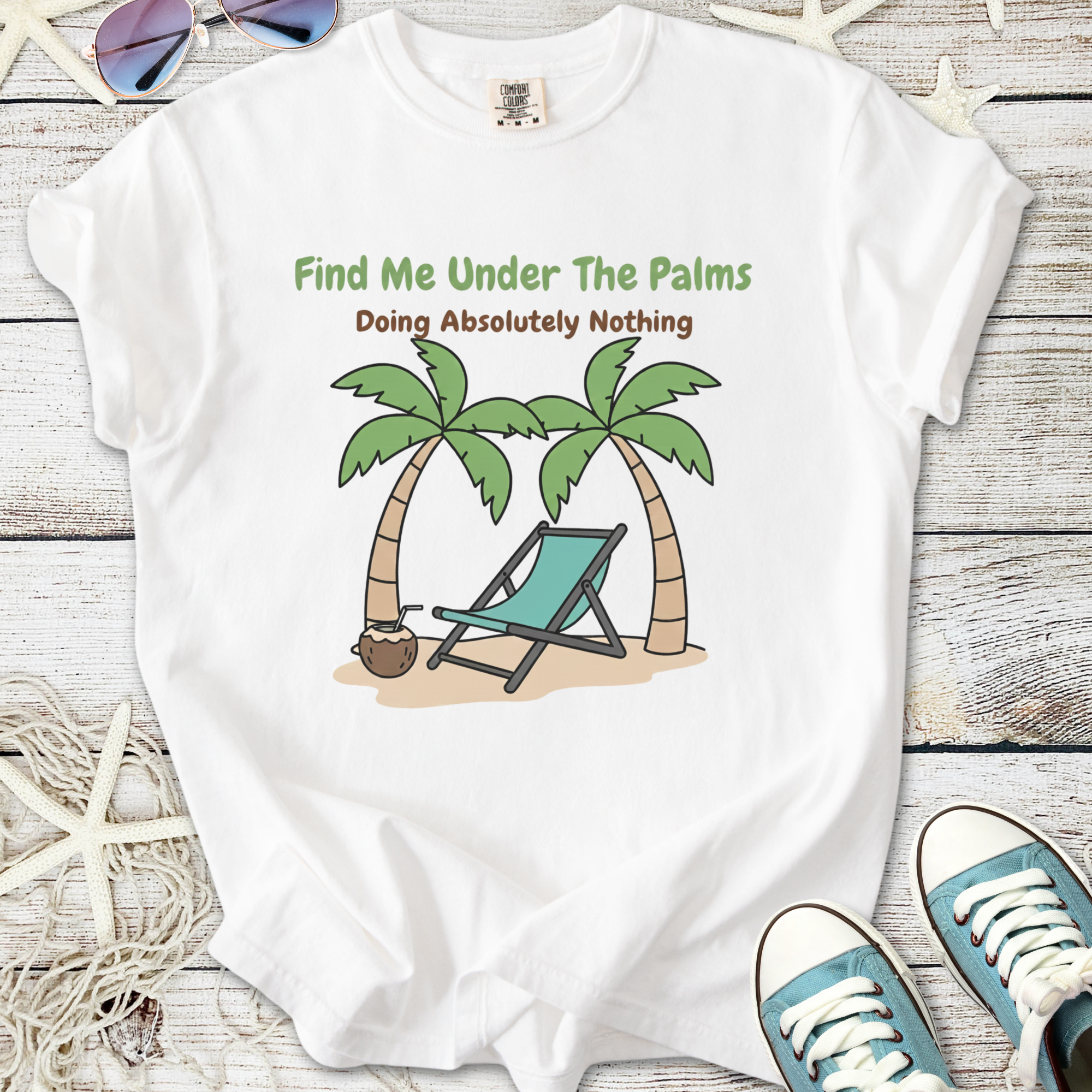 White unisex t-shirt with 'Find Me Under The Palms' graphic, featuring palm trees and a beach chair.