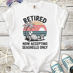 White t-shirt featuring a turtle graphic with 'Retired' text and a beach sunset design.