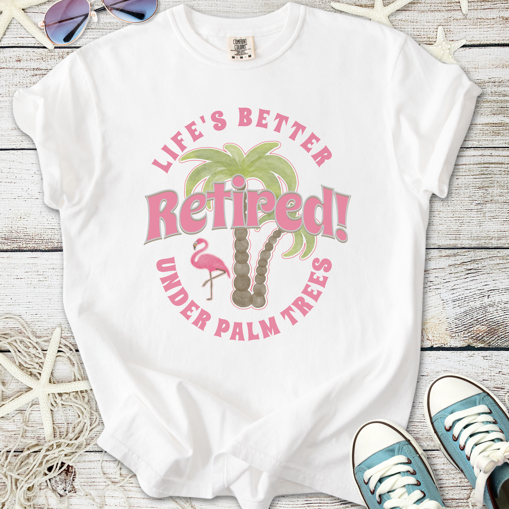 White t-shirt with 'Life's Better Retired!' print, featuring palm trees and a pink flamingo design.