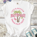 White t-shirt with 'Life's Better Retired!' print, featuring palm trees and a pink flamingo design.