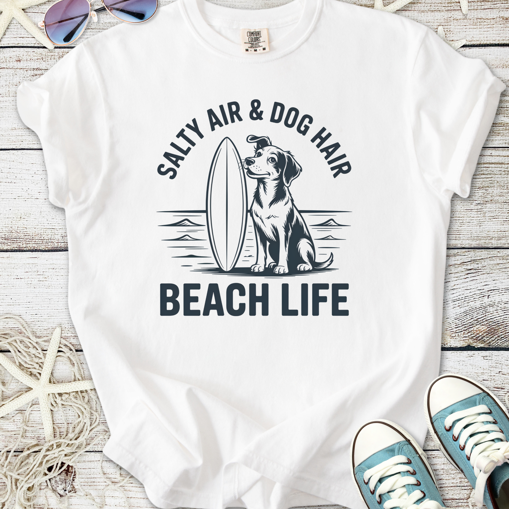 White t-shirt featuring a dog and surfboard graphic, perfect for beach lovers and dog owners.