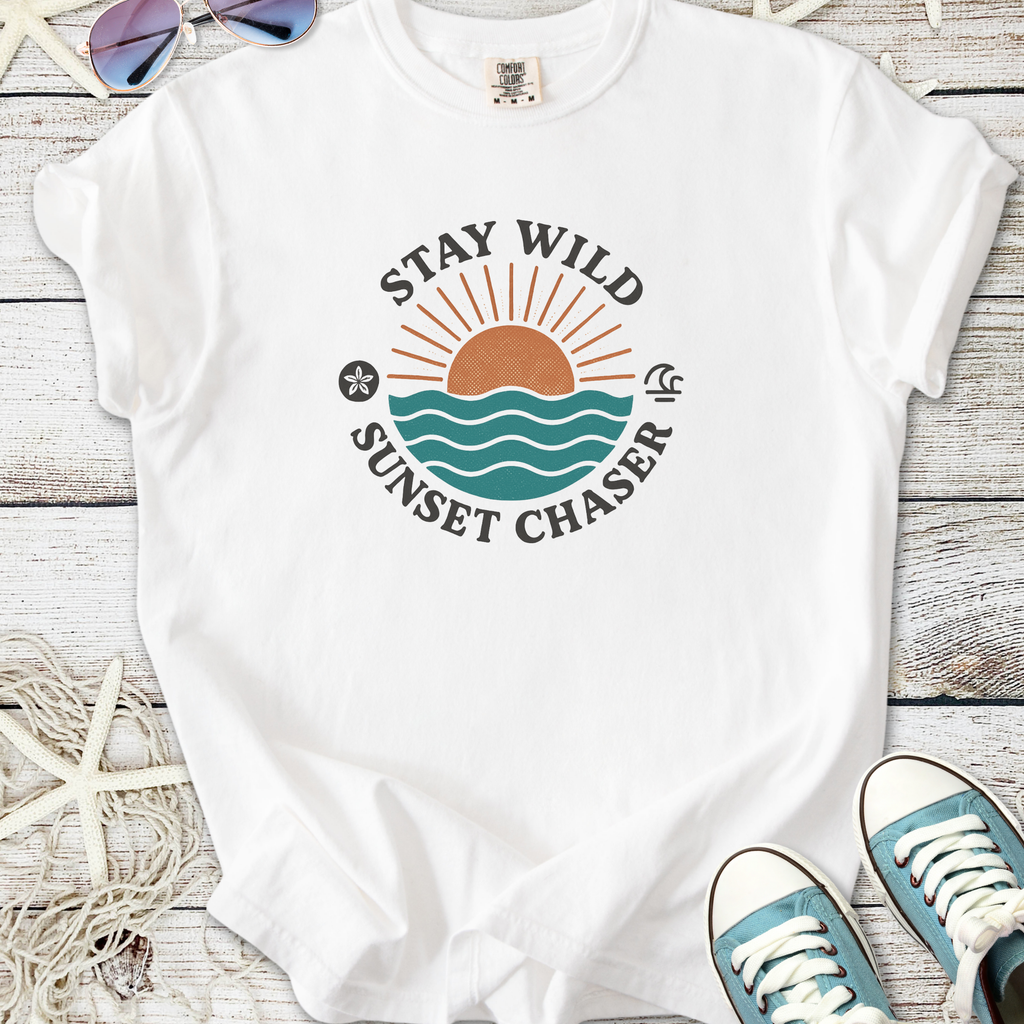 White t-shirt with 'Stay Wild Sunset Chaser' graphic, beach-themed design, perfect for casual summer wear.