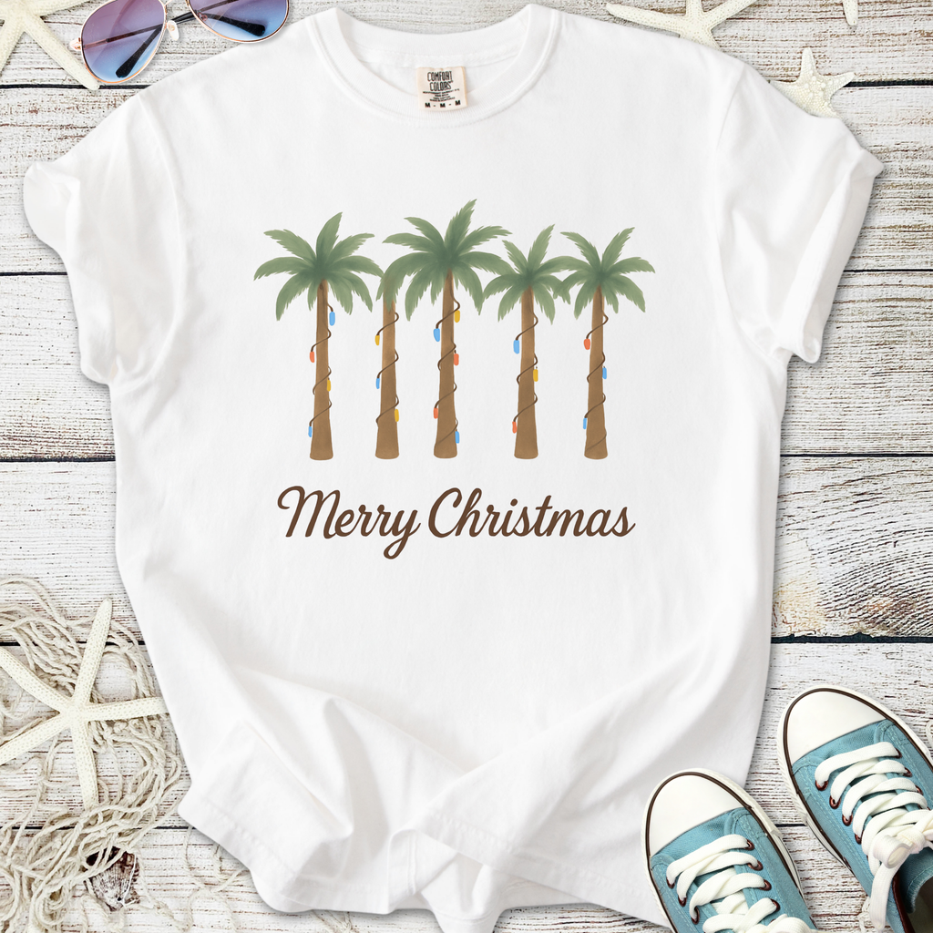 White Christmas t-shirt featuring palm trees adorned with colorful lights and 'Merry Christmas' text.
