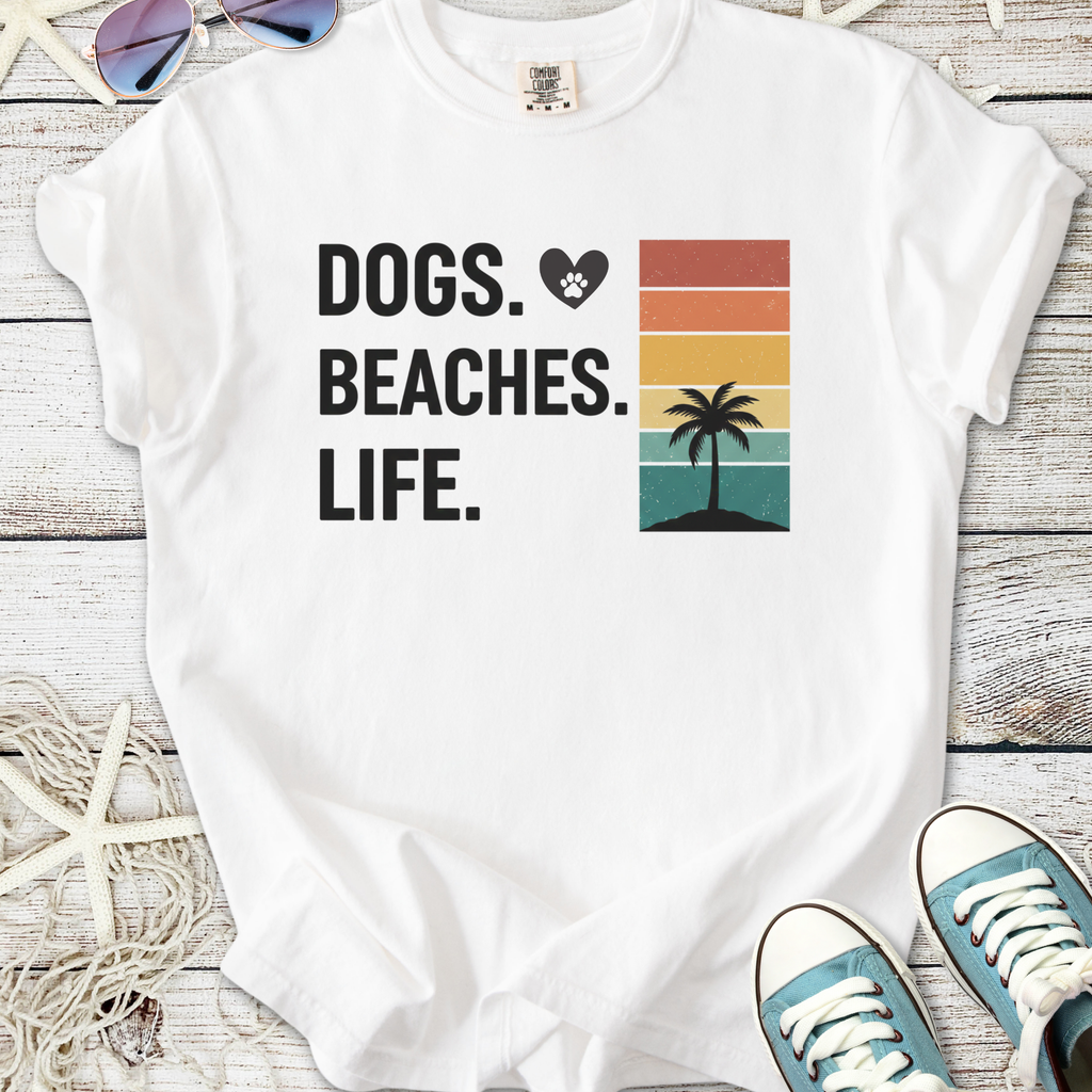 White graphic tee featuring text 'Dogs. Beaches. Life.' and palm tree design, perfect for beach lovers.