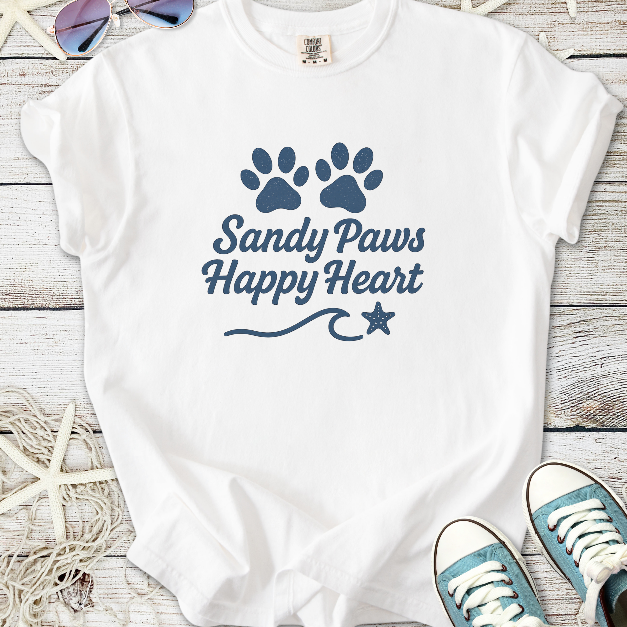 White t-shirt with 'Sandy Paws Happy Heart' design and paw prints, perfect for beach lovers.