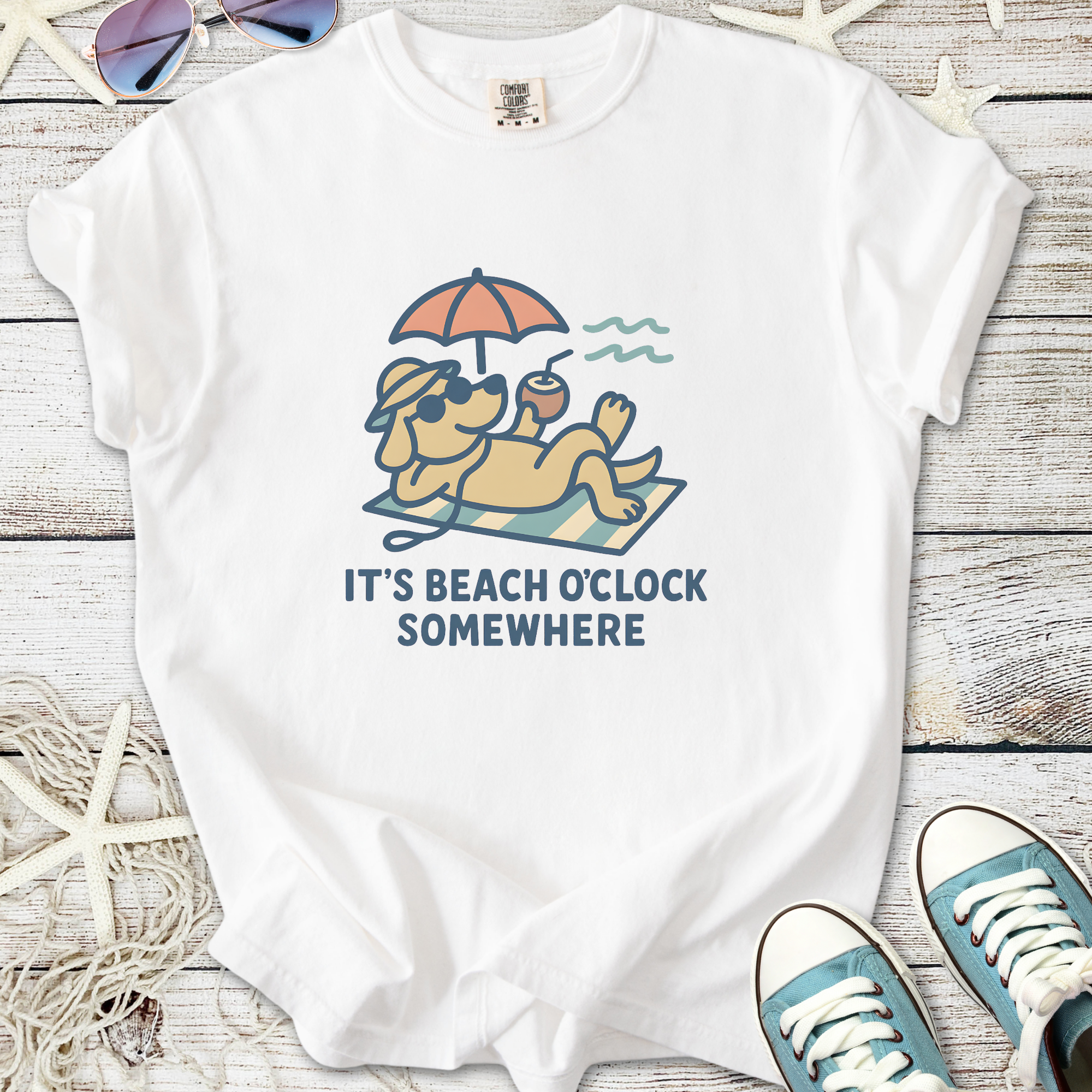 White graphic tee featuring a relaxing dog with sunglasses and text 'It's Beach O'Clock Somewhere'