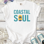 White t-shirt with 'Coastal Soul' graphic featuring a palm tree and sun, perfect for casual beachwear.