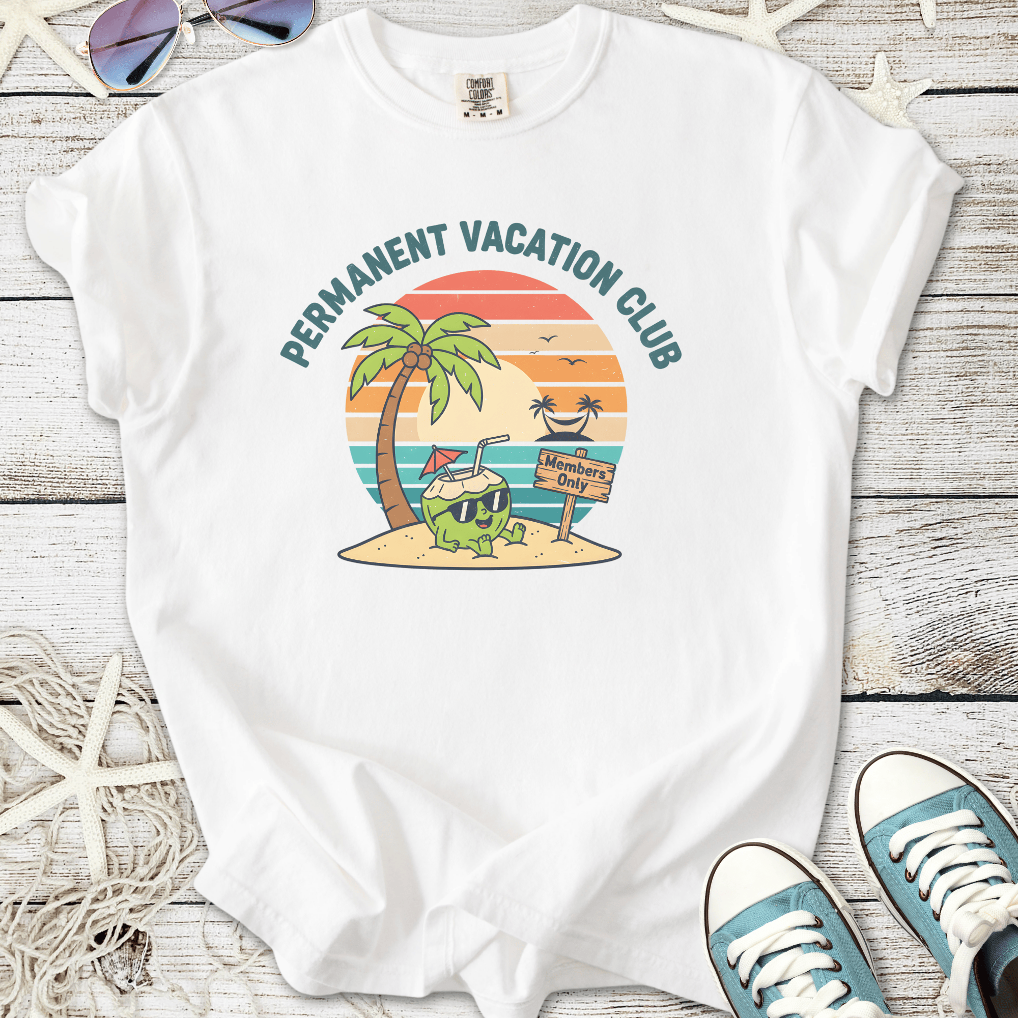 White t-shirt featuring 'Permanent Vacation Club' graphic with palm tree and beach design.