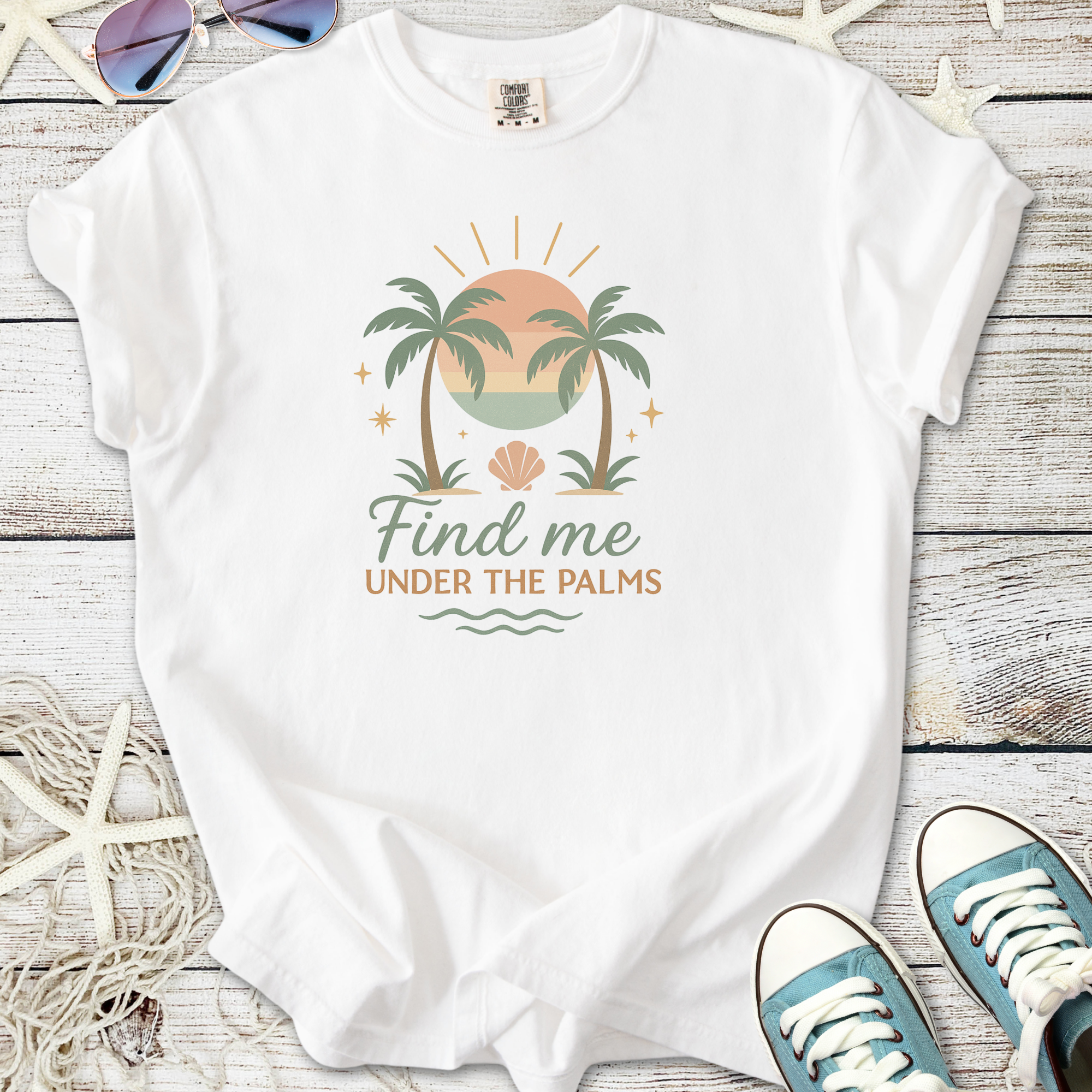 White unisex t-shirt with 'Find me under the palms' graphic, featuring palm trees and a sunset design.
