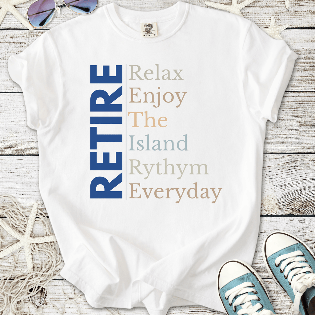 White t-shirt with 'RETIRE' graphic, featuring relaxed island-themed text in blue and pastel colors.