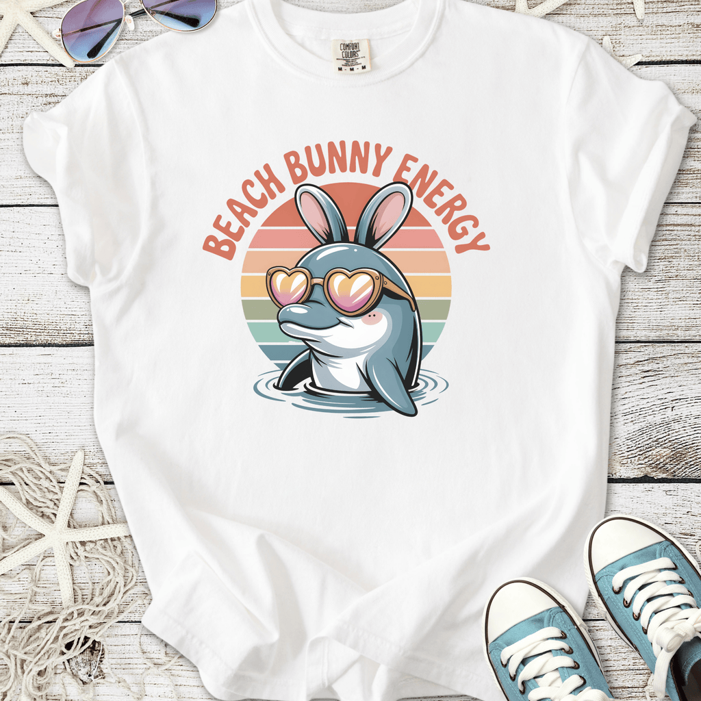 White t-shirt with a dolphin wearing bunny ears and sunglasses, featuring 'Beach Bunny Energy' text.