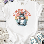 White t-shirt with a dolphin wearing bunny ears and sunglasses, featuring 'Beach Bunny Energy' text.