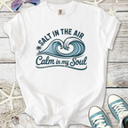 White graphic t-shirt featuring ocean waves and text 'Salt in the Air, Calm in my Soul' for beach lovers.