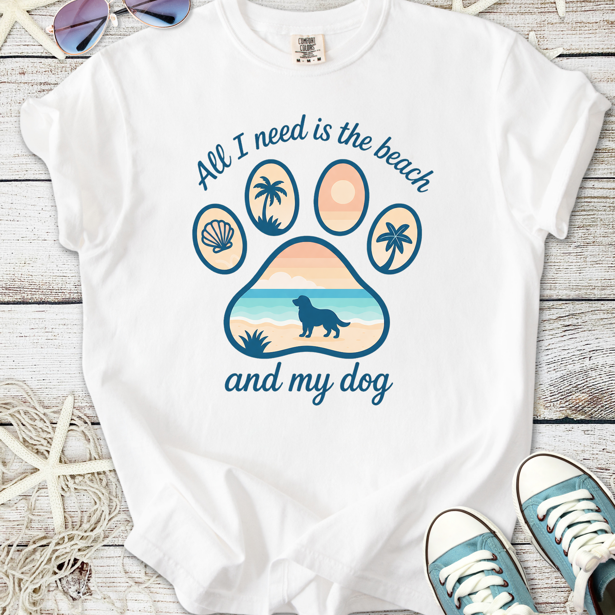 White t-shirt with beach-themed paw print graphic, featuring 'All I need is the beach and my dog' text.