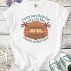 White t-shirt featuring a Tiki bar graphic with palm trees, promoting relaxation and self-care.