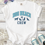 White t-shirt featuring 'Dog Beach Crew' print with dog silhouettes, perfect for beach outings.